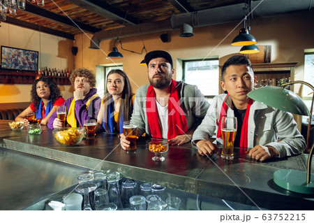 Sport fans cheering at bar, pub and drinking beer while championship, competition is going 63752215