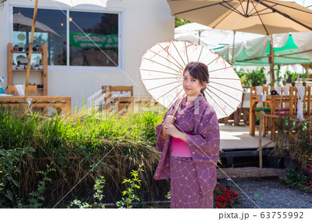 The girl is wearing a pink traditional yukata, which is the national dress of Japan and Hold an umbrella 63755992