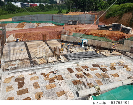 Building floor slab under construction. Construction workers fabricating the timber formwork and installing the steel reinforcement bar. Building floor slab under construction. Construction workers fabricating the timber formwork and installing the steel reinforcement bar. 63762402