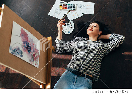 woman dreaming laying on the floor with sketches 63765877