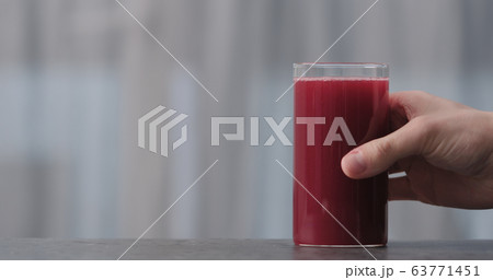 man hand take blackcurrant nectar in glass from concrete countertop with copy space man hand take blackcurrant nectar in glass from concrete countertop with copy space 63771451