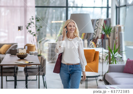 Pretty woman in a light blouse walking in the hall. Pretty woman in a light blouse walking in the hall. 63772385