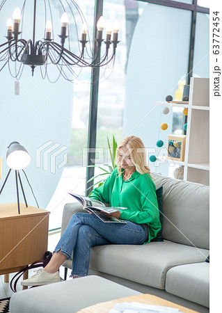 Blonde woman in a green blouse looking busy 63772454