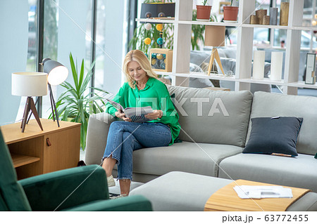 Blonde woman in a green blouse looking involved 63772455