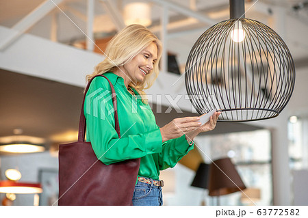 Blonde woman in a green blouse looking at the bird 63772582