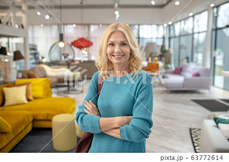 Blonde woman in a blue dress smiling nicely Blonde woman in a blue dress smiling nicely 63772614