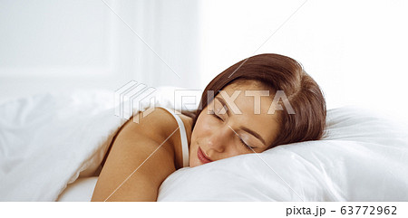 Photo Beautiful young woman sleeping while lying in bed comfortably and  blissfully