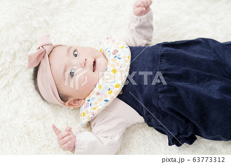 仰向けに寝転がる7ヶ月の女の子 63773312