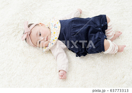 仰向けに寝転がる7ヶ月の女の子 63773313