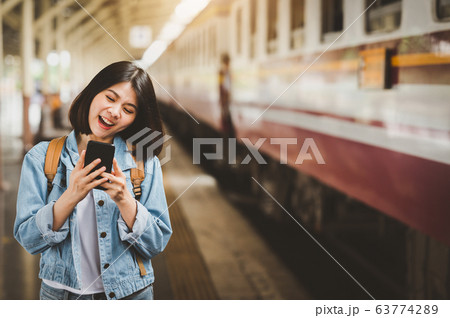 happy woman traveler with smartphone at train happy woman traveler with smartphone at train 63774289