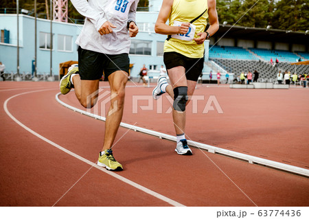 two man athletes run on track 63774436