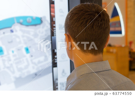 A man near the interactive map of the supermarket. 63774550