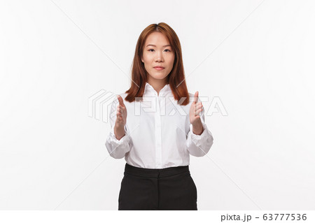 Portrait of young elegant asian woman in office clothes, pointing at camera, showing way, female instructor give directions, teaching new flight attendants, standing white background Portrait of young elegant asian woman in office clothes, pointing at camera, showing way, female instructor give directions, teaching new flight attendants, standing white background 63777536
