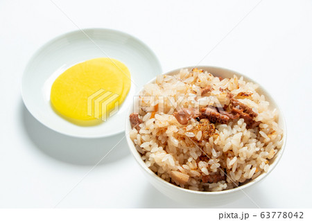 たこめし・タコの炊き込みご飯。写真奥には漬物(たくあん漬け)。(白バック) たこめし・タコの炊き込みご飯。写真奥には漬物(たくあん漬け)。(白バック) 63778042