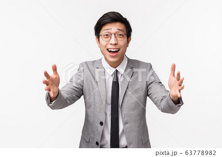 Waist-up of silly and cute asian male office manager, come home and reaching hands forward to cuddle his little sister, smiling touched, look with love and care, wear grey suit, white background Waist-up of silly and cute asian male office manager, come home and reaching hands forward to cuddle his little sister, smiling touched, look with love and care, wear grey suit, white background 63778982