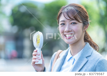 ビジネスウーマン　若い女性　ミニ扇風機 63779567