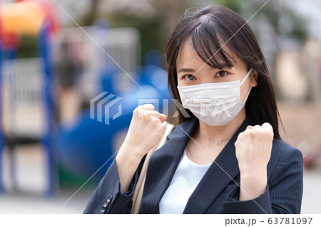 ファイティングポーズをするマスクをする若い女性 63781097