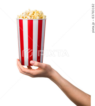 Woman hand holding striped bucket with popcorn Woman hand holding striped bucket with popcorn 63783182