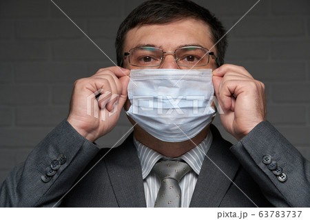 a man puts a mask on his face for antivirus 63783737