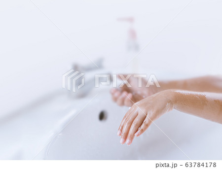 The girl is washing hands with soap to prevent 63784178