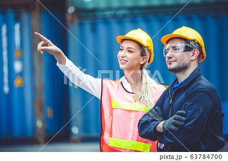 logistic worker man and woman working team with radio control loading containers at port cargo 63784700