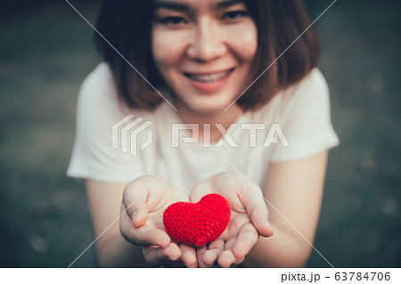 girl teen smile with red heart in hand for giving help donation medical healthcare concept. 63784706