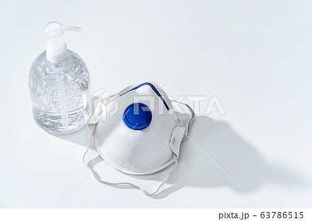 Anti-septic hand gel and N95 mask on white table 63786515