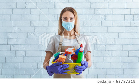 Girl in protective mask with cleaning supplies 63787219