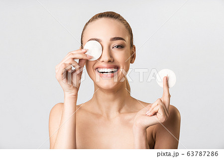 Blonde Girl Covering Eye With Cotton Pad Having Fun, Studio Blonde Girl Covering Eye With Cotton Pad Having Fun, Studio 63787286