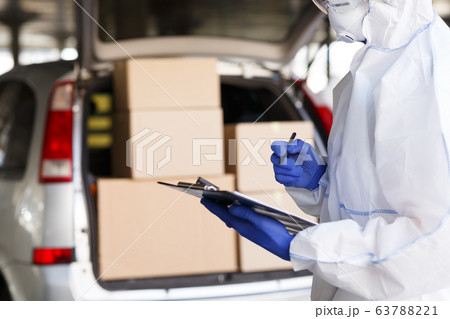 Man in virus protective suit delivering products to people 63788221