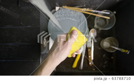 Washing dirty dishware in black sink Washing dirty dishware in black sink 63788710