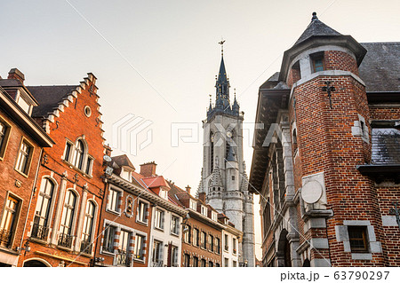 Tall medieval bell tower rising over the street 63790297
