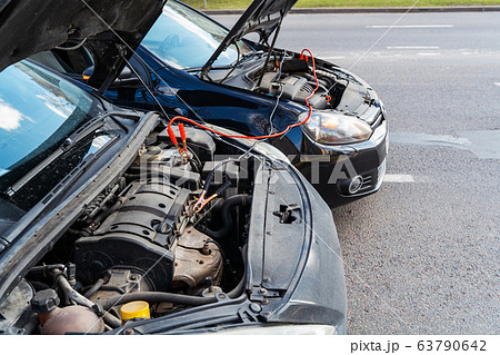 Jump cables on car battery Jump cables on car battery 63790642
