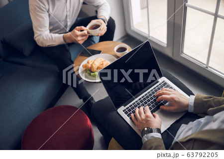 Businessman typing on laptop in cozy apartment Businessman typing on laptop in cozy apartment 63792205