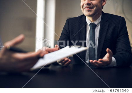 Cropped photo of male colleagues discussing their plans indoors Cropped photo of male colleagues discussing their plans indoors 63792540
