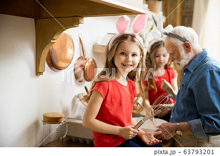 Delighted girl enjoying cooking with family stock photo Delighted girl enjoying cooking with family stock photo 63793201