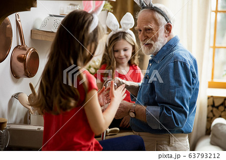 Happy grandpa cooking and talking to girl stock photo Happy grandpa cooking and talking to girl stock photo 63793212