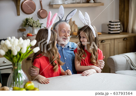 Mirthful aged man with his granddaughters stock photo Mirthful aged man with his granddaughters stock photo 63793564