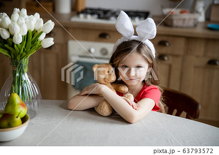 Lovely girl with her toy in the kitchen stock photo 63793572