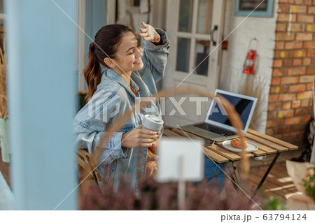 Cute modern girl sitting at a computer outdoors 63794124