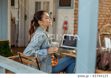 Dark-haired young woman relaxing at lunch time 63794125