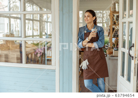 Pleased girl leaning against a door frame 63794654