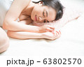 ベッドで眠る女性 63802570