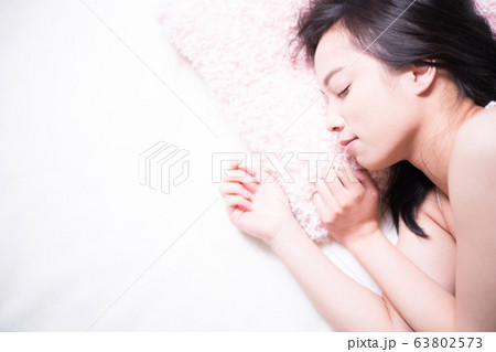ベッドで眠る女性 63802573