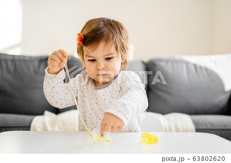 Small toddler girl playing slime at home. Activity for child at home Small toddler girl playing slime at home. Activity for child at home 63802620
