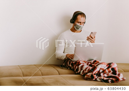 man with laptop and smartphone during quarantine 63804430
