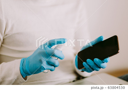 man desinfecting smarphone with aniseptic gel man desinfecting smarphone with aniseptic gel 63804530