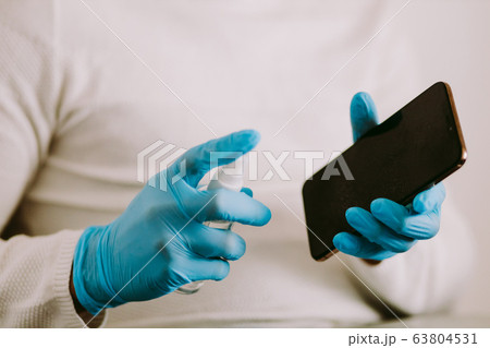 man desinfecting smarphone with aniseptic gel man desinfecting smarphone with aniseptic gel 63804531