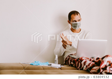 man desinfecting hands with hand sanitizer and 63804532