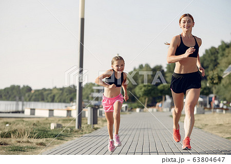 Mother with daughter doing sport in a summer park 63804647